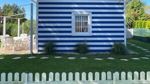 A two-story house with a gabled roof and a white picket fence in front. - House with 2 bedrooms near of the forest and sea. (Województwo pomorskie)