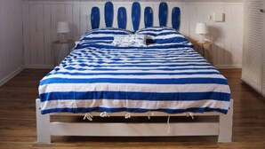 A bedroom with a wooden bed, white walls, and a sloped ceiling. - House with 2 bedrooms near of the forest and sea. (Województwo pomorskie)