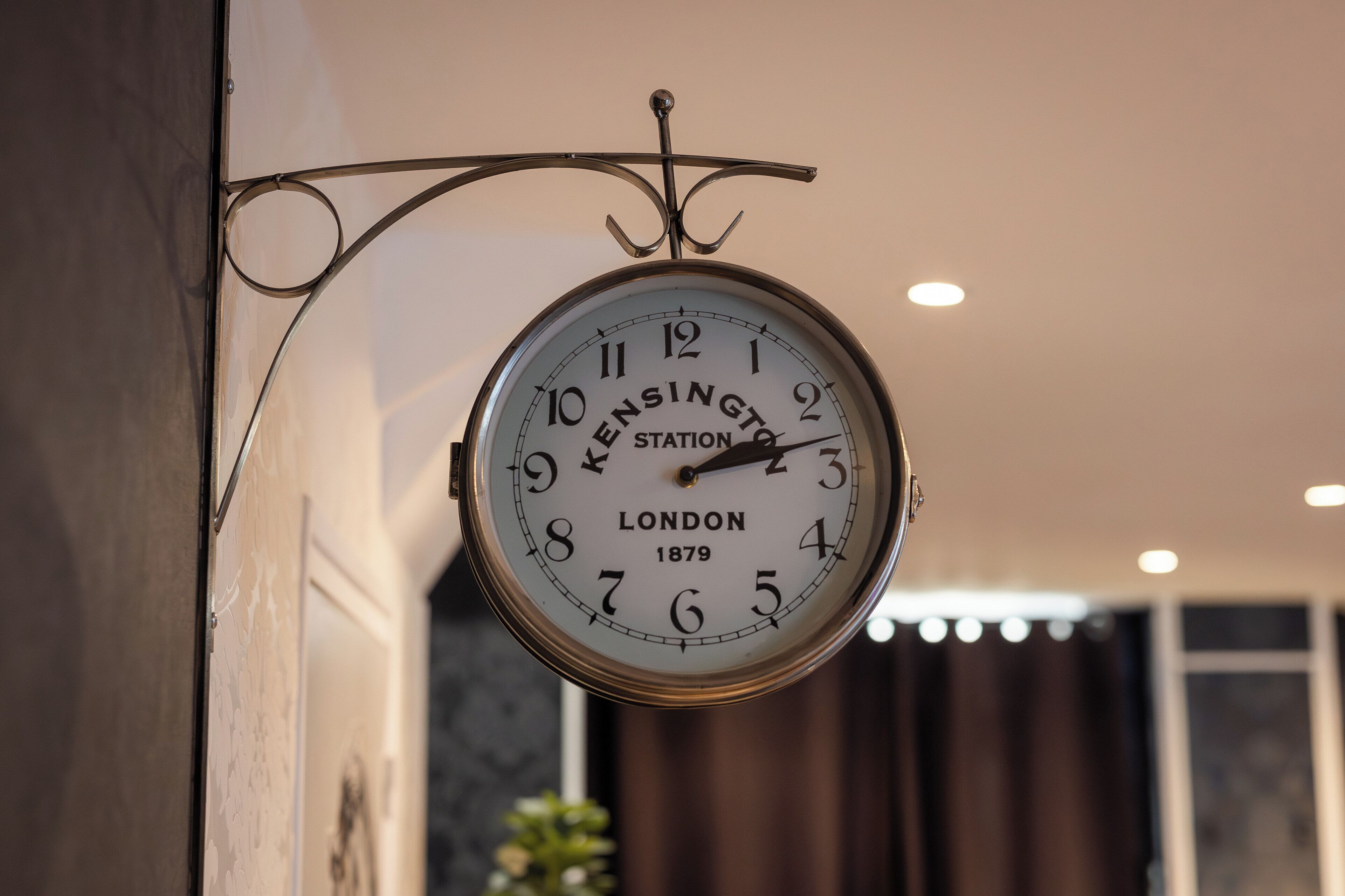 A wall-mounted clock with the inscription "Kensington Station London 1879".