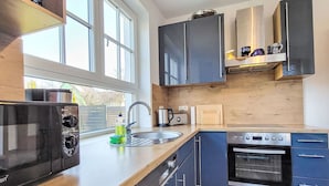 Une cuisine moderne dotée d’une grande fenêtre, d’un four à micro-ondes encastré, d’un grille-pain et d’une cuisinière.
