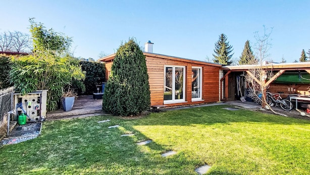 Une maison en bois avec une pelouse bien entretenue et un garage.