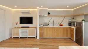 A modern kitchen with wooden cabinets, a built-in microwave, and a stainless steel refrigerator.