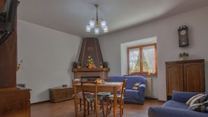 Una sala acogedora con chimenea, comedor y sofá.