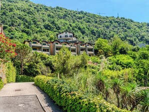 Ein mehrstöckiges Hotel mit Innenhof, umgeben von üppiger Vegetation und einer Hanglage.
