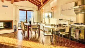Una cucina moderna con isola centrale, pavimento in legno e zona pranzo con vista.
