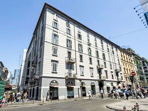 Ein mehrgeschossiges Gebäude im klassischen Stil, mit einem Eingangsbereich im Erdgeschoss und Beschilderung.