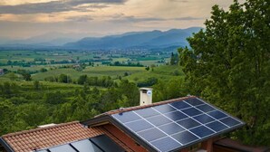 Een modern huis met zonnepanelen, een jacuzzi en uitzicht op het platteland.
