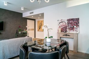 Una sala de estar moderna con una mesa de comedor de vidrio, un sofá y una chimenea.
