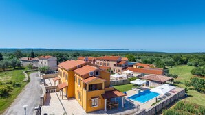 Zona residencial con varios edificios, piscina y vista despejada al mar.