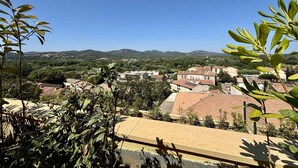 Ein Wohngebiet mit Häusern, blauem Himmel und Bergen im Hintergrund.