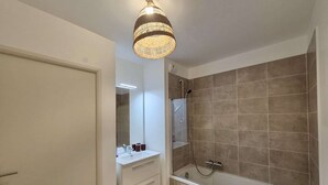 A modern bathroom with a shower, a toilet, and a vanity with a mirror. - 3-Room Apartment in Cogolin, 4 Pers with Parking Included (Cogolin)