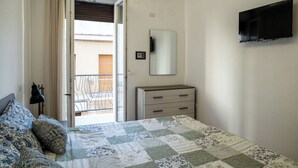 A bedroom with a bed, a dresser, a mirror, and a TV. - Cosy apartment for 4 guests with A/C, TV and balcony (Termoli)