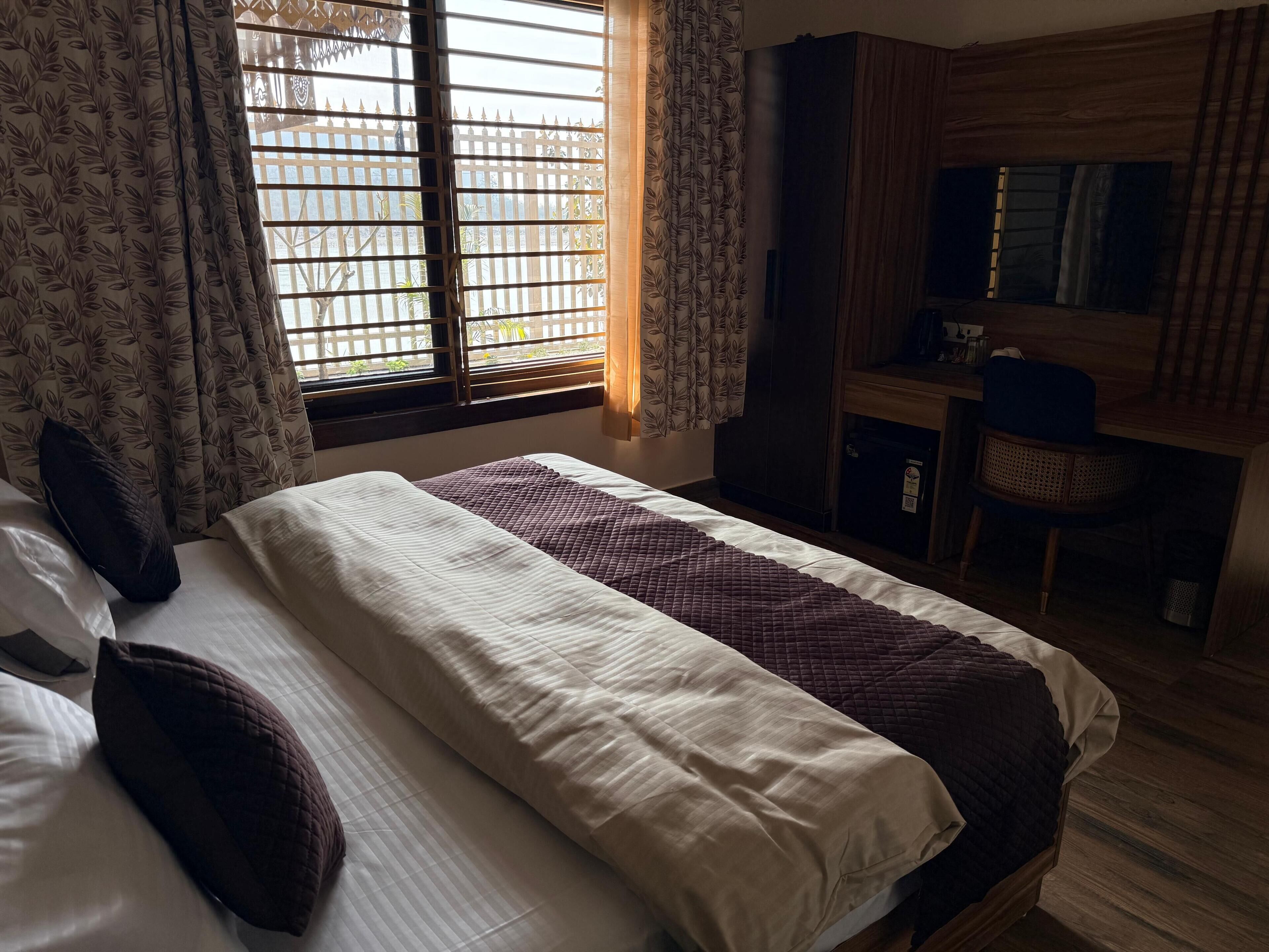 Een hotelkamer met een bed, een bureau en een stoel.