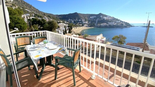 A balcony with a table and chairs, overlooking a coastal town and the sea. - Beautiful apartment 200m from the beach with terrace and garage in Roses (Roses)