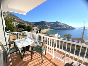 A balcony with a table and chairs, overlooking a coastal town and the sea. - Beautiful apartment 200m from the beach with terrace and garage in Roses (Roses)