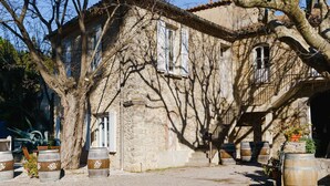 A stone building with a rustic facade, large windows, and a staircase leading to an upper level. - Charming 2-Bedroom Cottage in Vineyard Estate, Near Narbonne-Plage, Sleeps 5, with WiFi and Parking (Narbonne-Narbonne Plage-Narbonne Plage)