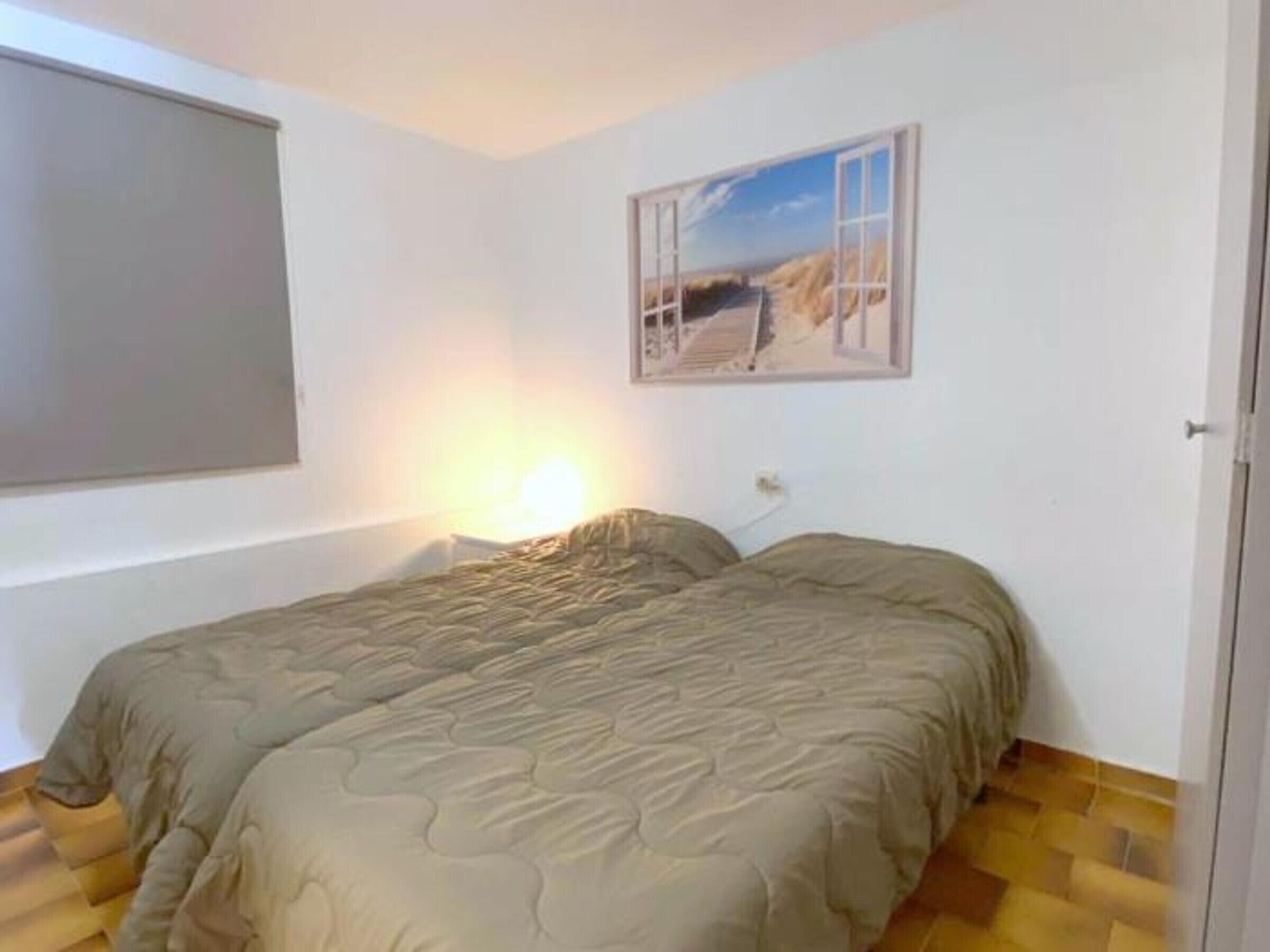 Una camera da letto con un letto, una finestra e un quadro appeso al muro.