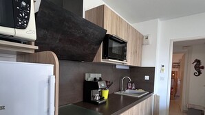 Eine moderne Küche mit Mikrowelle, Kaffeemaschine und Spüle.