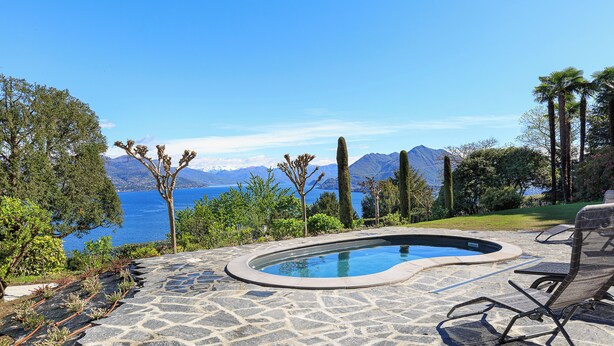 Una piscina de piedra con vistas al mar y a las montañas.