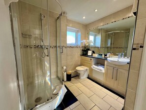 Un baño moderno con ducha de vidrio, inodoro y lavamanos.