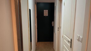 A narrow hallway with wooden flooring, white walls, and closed doors on both sides. - La Foux, T3 for 6 people, south-facing, terrace at the foot of the slopes (Allos)