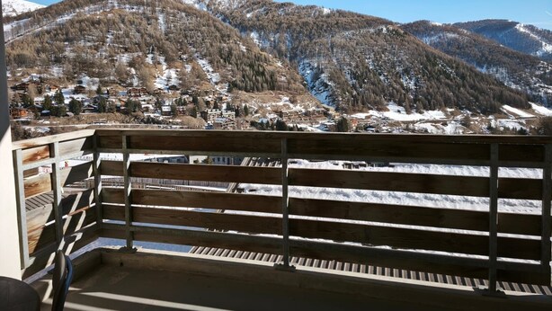 A balcony with a view of a mountainous landscape, including snow-covered slopes and a village below. - La Foux, T3 for 6 people, south-facing, terrace at the foot of the slopes (Allos)