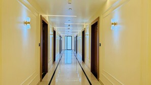 A long, well-lit hallway with doors on both sides, leading to a bright room at the end. - Kreston Heights Hotels Bhopal (Bhopal)