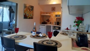 Ruokailutila, jossa on kahdelle katettu pöytä, viinipullo ja punaviinilasi.