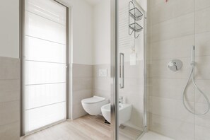 Chuveiro, bidê, toalhas de banho 