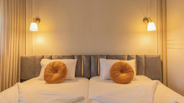 A double bed with two pillows, a headboard, and two wall-mounted lamps. - 1 BR Apartment in Ha-Neviim (w/ safe room) (Jerusalem)