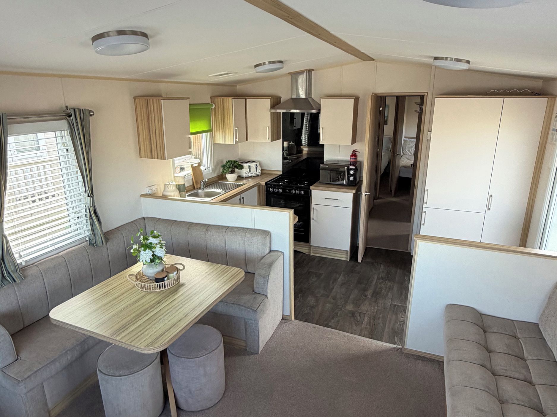A compact kitchenette with a stove, microwave, and sink.