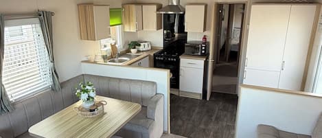 A compact kitchenette with a stove, microwave, and sink.