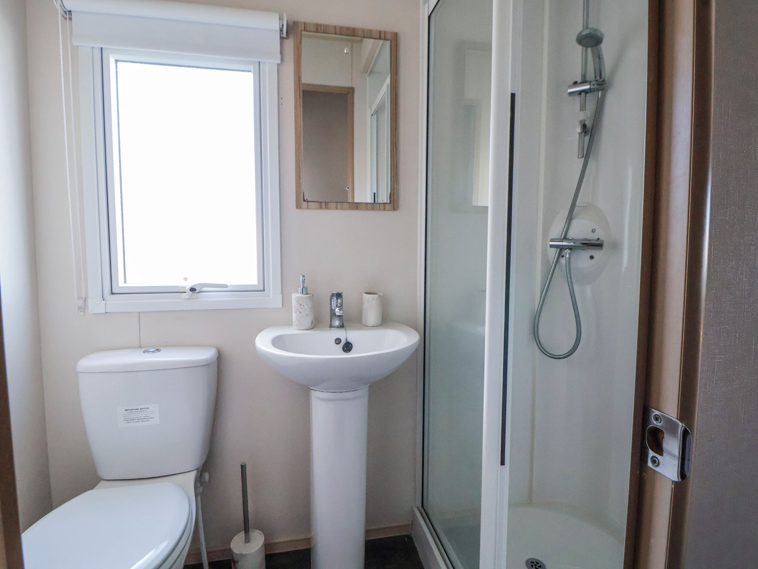 A bathroom with a toilet, sink, and glass-enclosed shower.