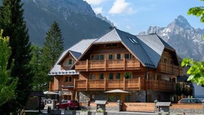 Un chalet en bois doté d’un balcon, situé dans un cadre montagneux.