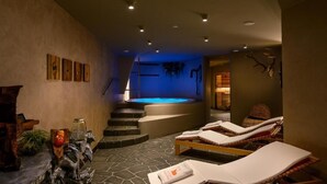 Un centre de bien-être doté d’un bain à remous, de chaises longues et d’un escalier menant à un niveau supérieur.