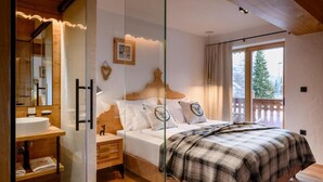 Une chambre à coucher avec un lit, une table de chevet et une fenêtre donnant sur des arbres.