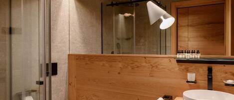 Ein modernes Badezimmer mit einer Duschkabine aus Glas, einem Holzbadezimmer-Möbel und einem großen Spiegel.