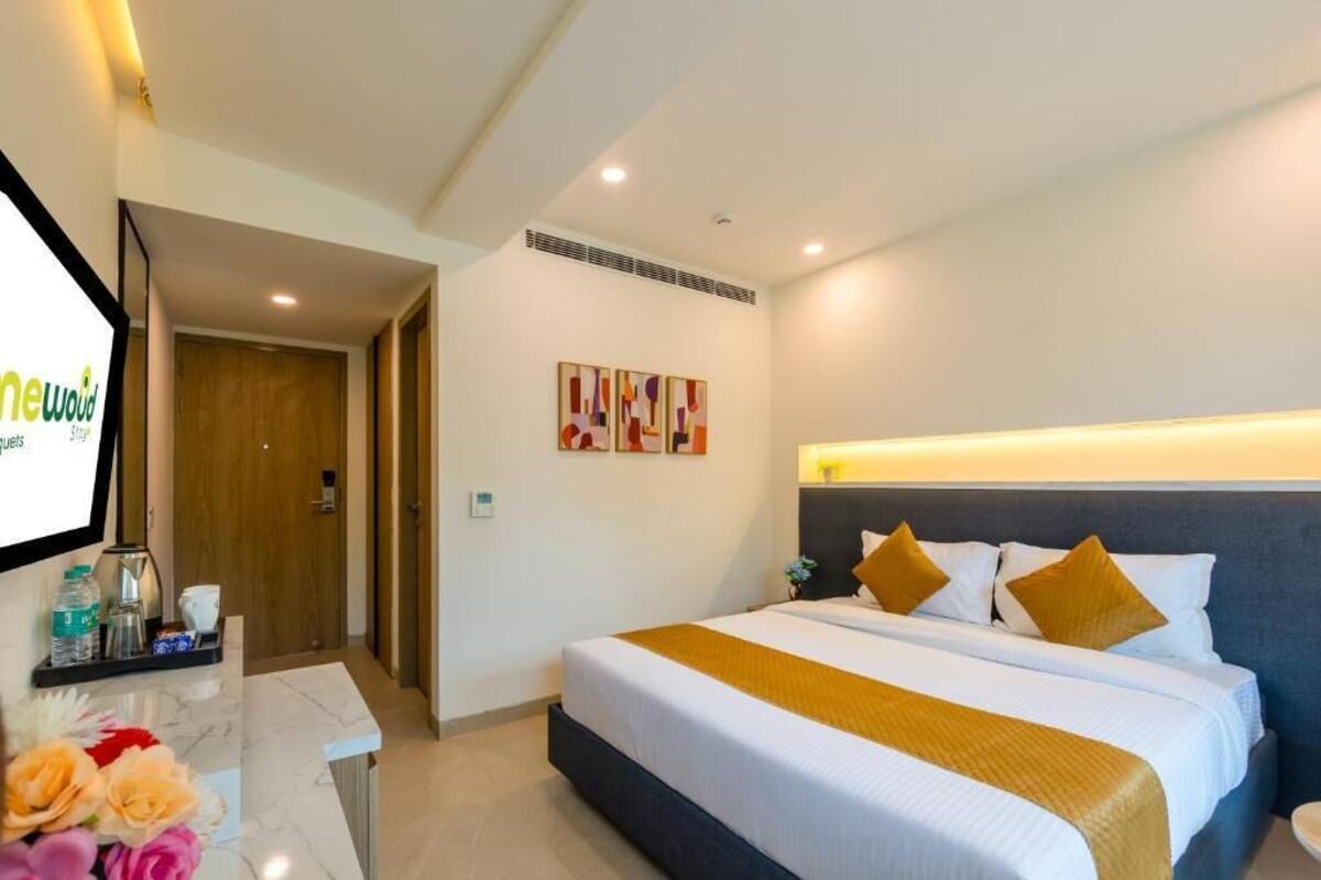 Una habitación de hotel con una cama, un escritorio con computadora y televisor.