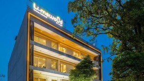 A modern hotel with a two-story structure, a visible restaurant on the ground floor, and a well-lit entrance. - Limewood Signature-Golf Course Extension (Gurugram)