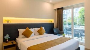 A modern hotel room with a large bed, a bedside table, and a view of the outdoors. - Limewood Signature-Golf Course Extension (Gurugram)