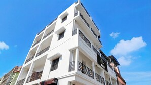 Un edificio de varios pisos con balcones, ventanas y cielo despejado.