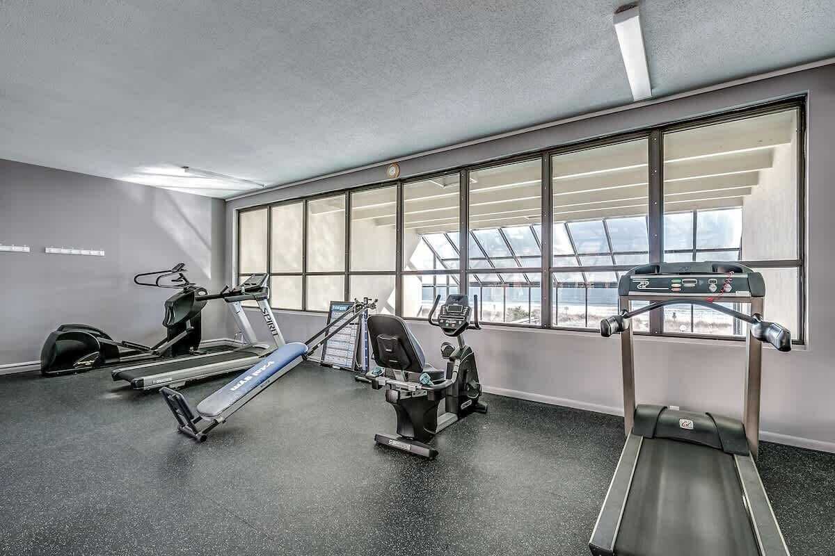 A gym with treadmills, elliptical machines, and a stationary bike.