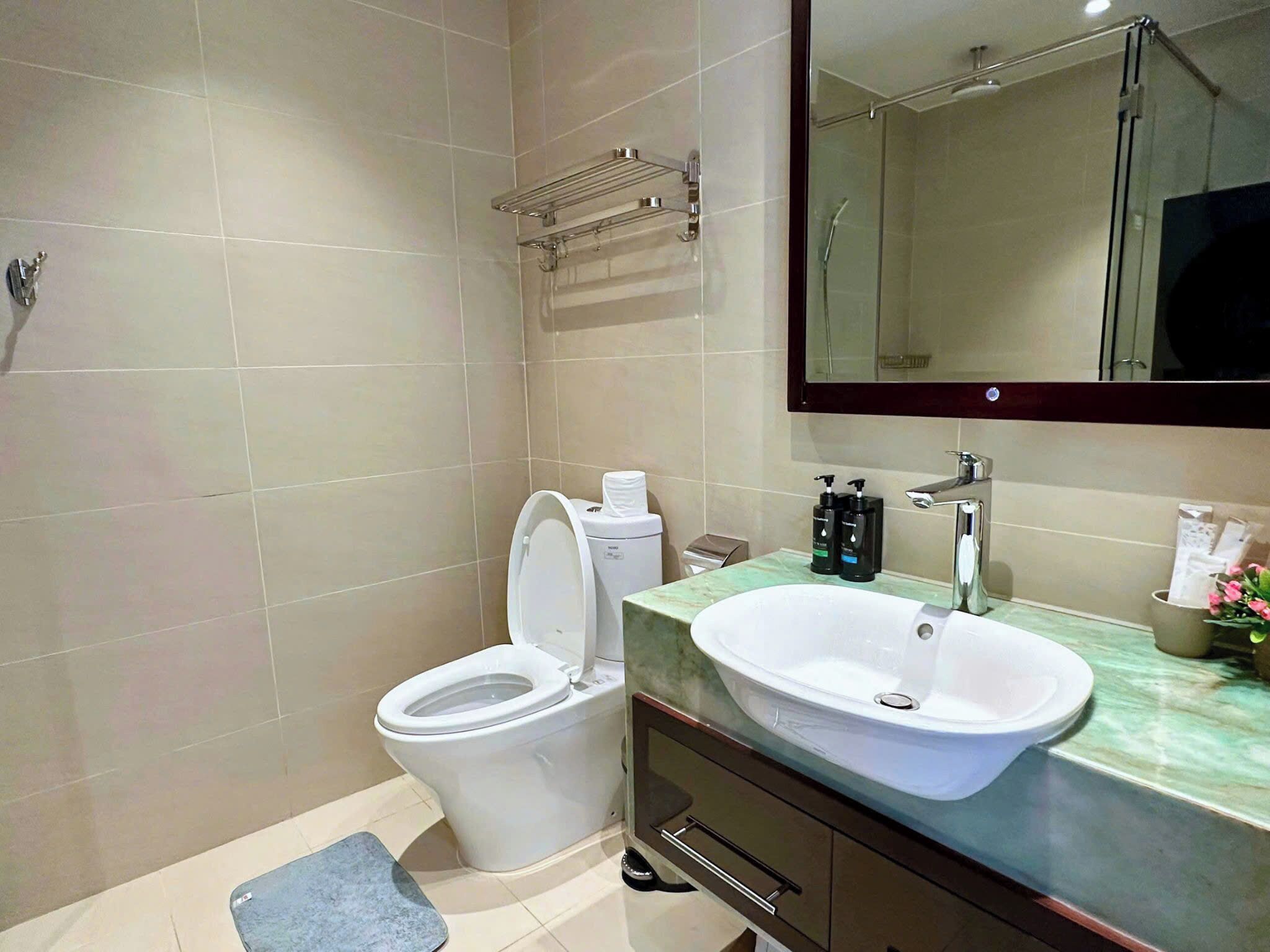 Un bagno moderno con toilette, lavandino e doccia.