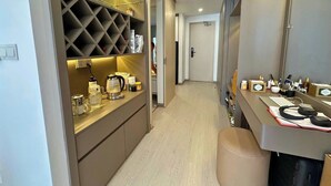 Una cocina moderna con un espacio para vinos, una cafetera y una encimera con varios objetos.
