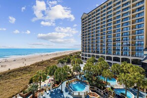 A hotel with a pool area, beach view, and multiple balconies. - Oceanfront 1BR  Beach Cove Resort  Sleeps 4 (North Myrtle Beach)