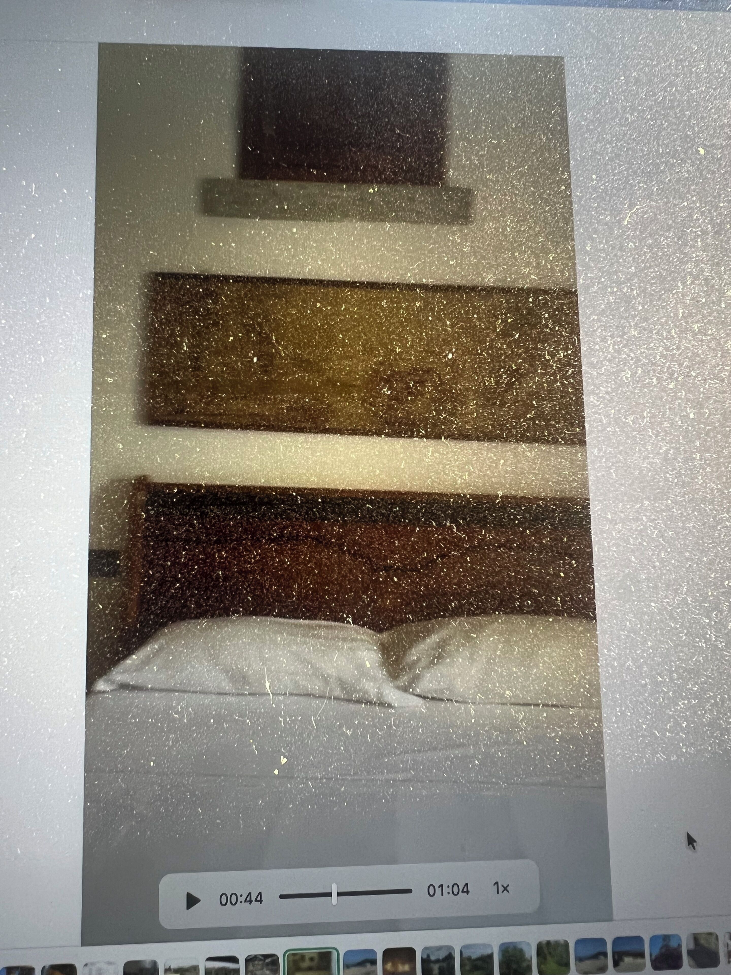 A room with a bed, a window, and a wall-mounted shelf.