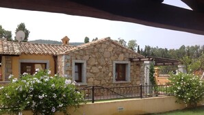 Edifici de pedra amb teulada de rajola, una paret groga i una finestra petita.