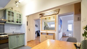A kitchen with a wooden table, cabinets, and a stove. - RentPlanet - Apartament Narutowicza (Kołobrzeg)