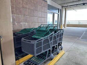 Carritos de compra apilados junto a una pared en un estacionamiento.