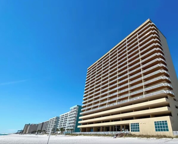 Un hotel de varios pisos con fachada plana y numerosas balcones.